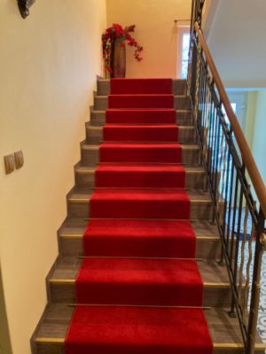 Červený behúň položený na schodisko v rodinnom dome